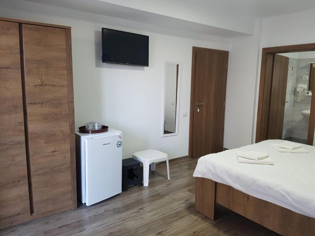 a bedroom with a bed and a tv on the wall at Vila La Matache in Eforie Nord