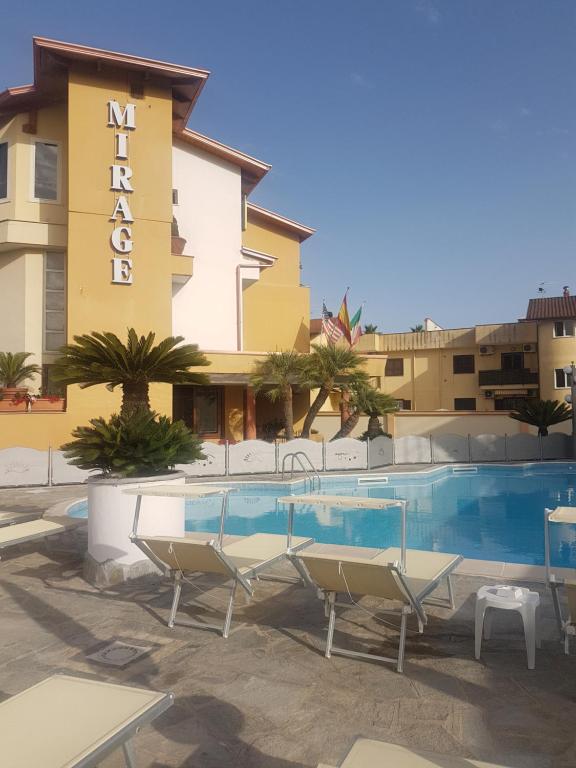a hotel with a swimming pool in front of a building at Hotel Mirage in Varcaturo