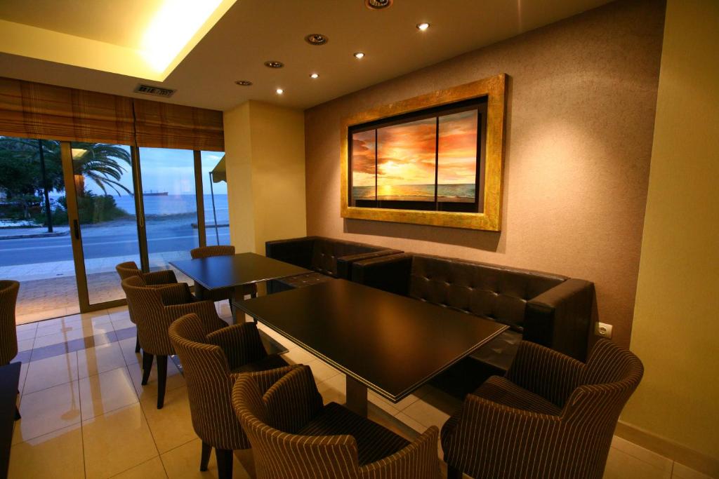a restaurant with tables and chairs and a picture on the wall at Hotel Flisvos in Kalamata