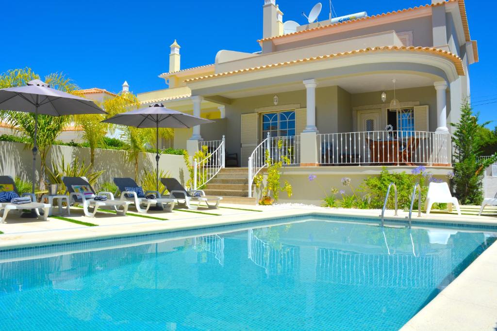 eine Villa mit einem Pool vor einem Haus in der Unterkunft VILA CRISTINA MAR (8 guests and oceanview) in Albufeira