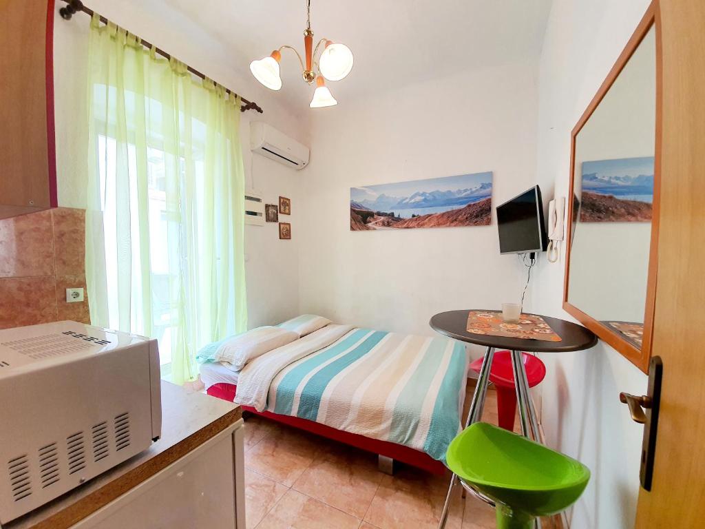 een slaapkamer met een bed, een tafel en een televisie bij Central Studio Apartment Agatha in Opatija