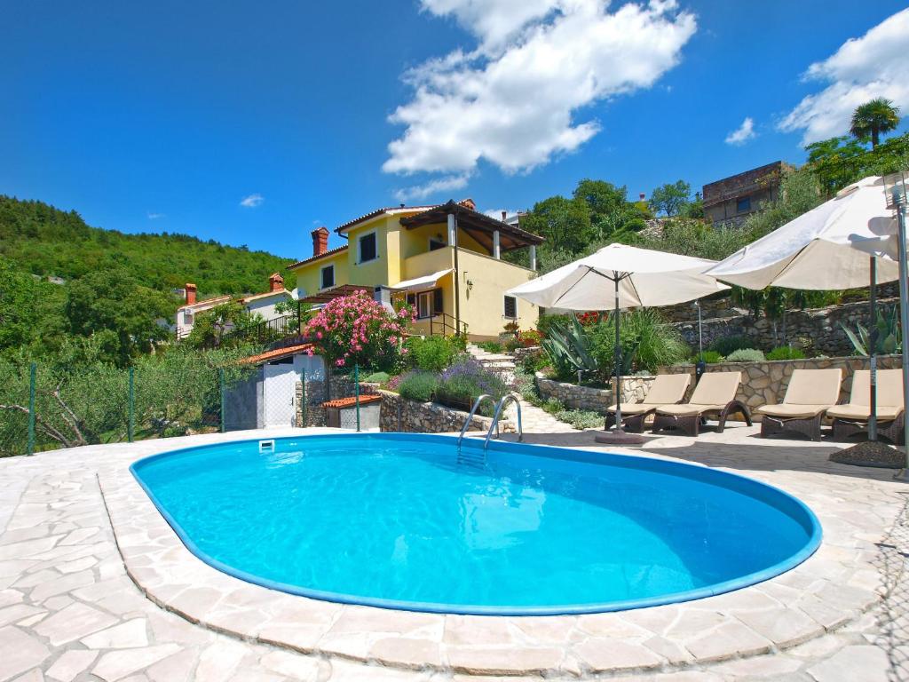 a swimming pool in a yard with a house at House Marija 2036 in Rabac