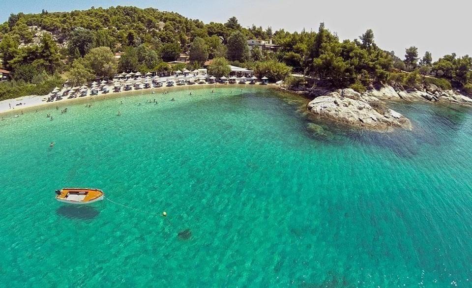 un barco en el agua en una playa en Akti Kalogria Hotel en Kalogria