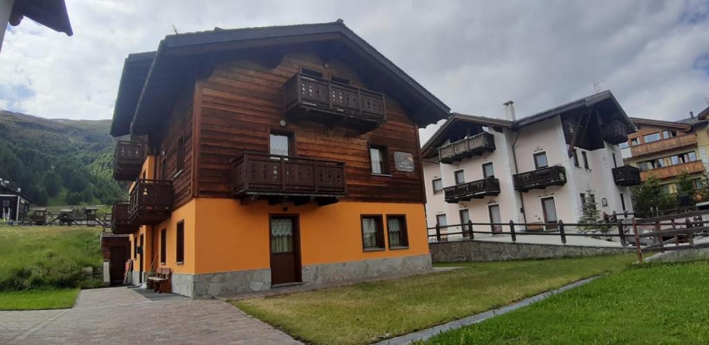 - un bâtiment en bois avec des balcons sur le côté dans l'établissement Chalet SUNFLOWER Appartamenti, à Livigno