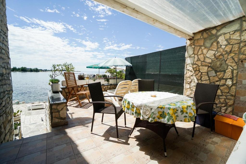 a patio with a table and chairs and the water at Sea view apartment Umag 1 in Umag