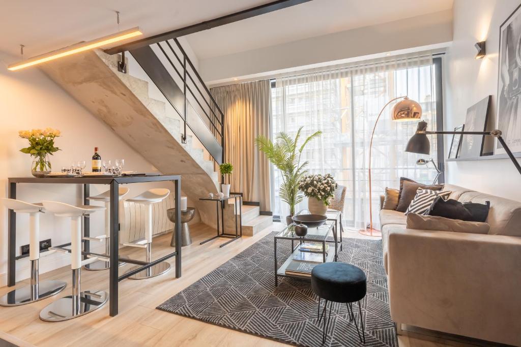 un salon avec un canapé et une table dans l'établissement B1 Loft Duplex 175Blo-Paris Convention, à Paris