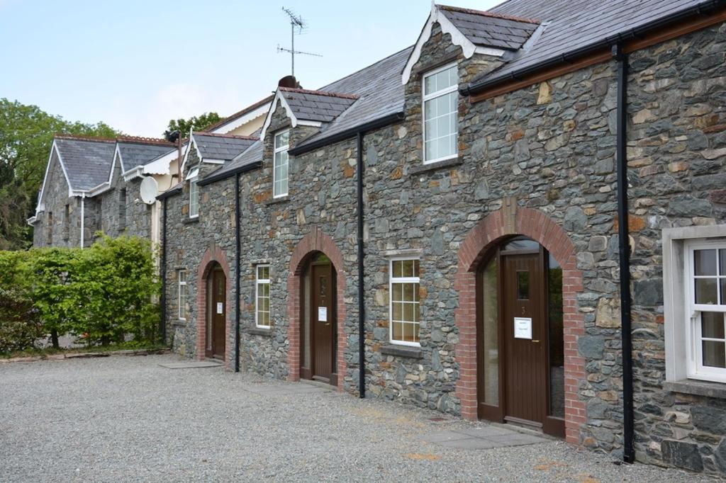 eine Reihe von Steingebäuden mit braunen Türen in der Unterkunft Killarney Country Club in Faha