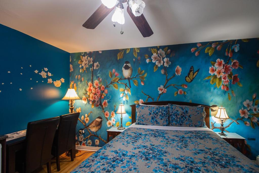 a bedroom with a bed with blue walls and flowers at Prince Street Suites in Charlottetown