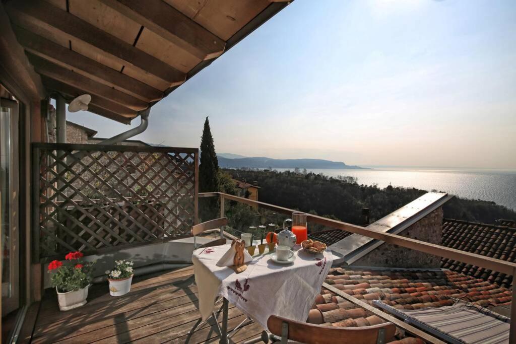 - une table sur un balcon avec vue sur l'eau dans l'établissement Betta - Newly Renovated Lake-View Terrace Apartment, Peaceful and Silent Surroundings, à Toscolano Maderno