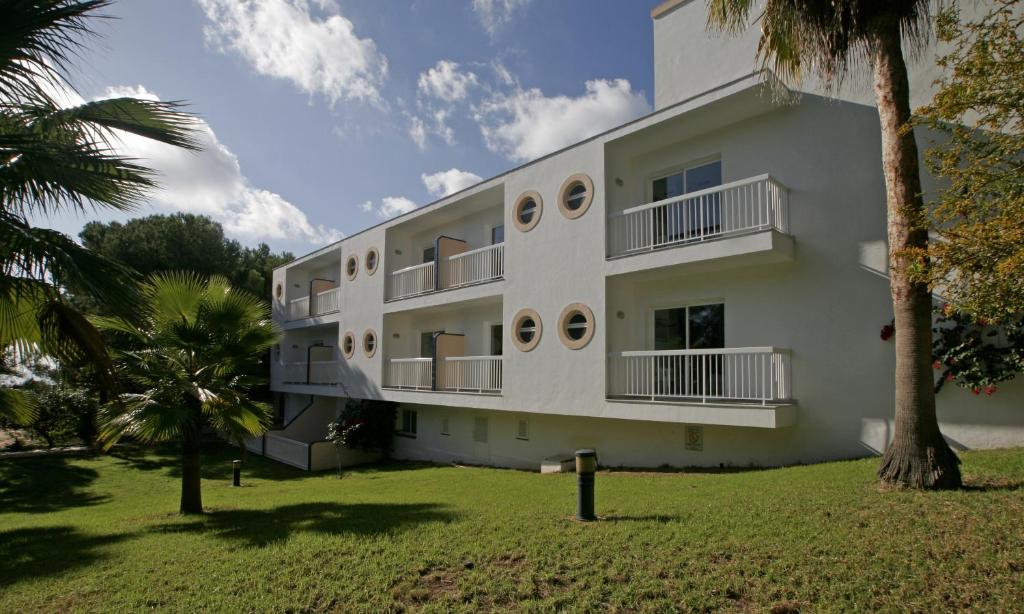 米喬爾海灘的住宿－艾斯皮2旅館，一座白色的大建筑,前面有棕榈树