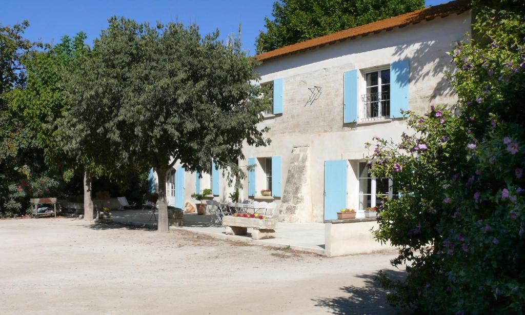 een wit huis met een boom ervoor bij manade Blanc - Gite la Fenière in Arles
