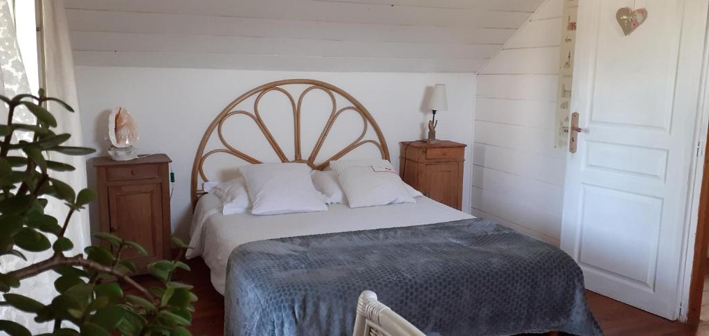 ein Schlafzimmer mit einem großen Bett mit weißen Kissen in der Unterkunft Gîte les petits chemins in Ledeuix