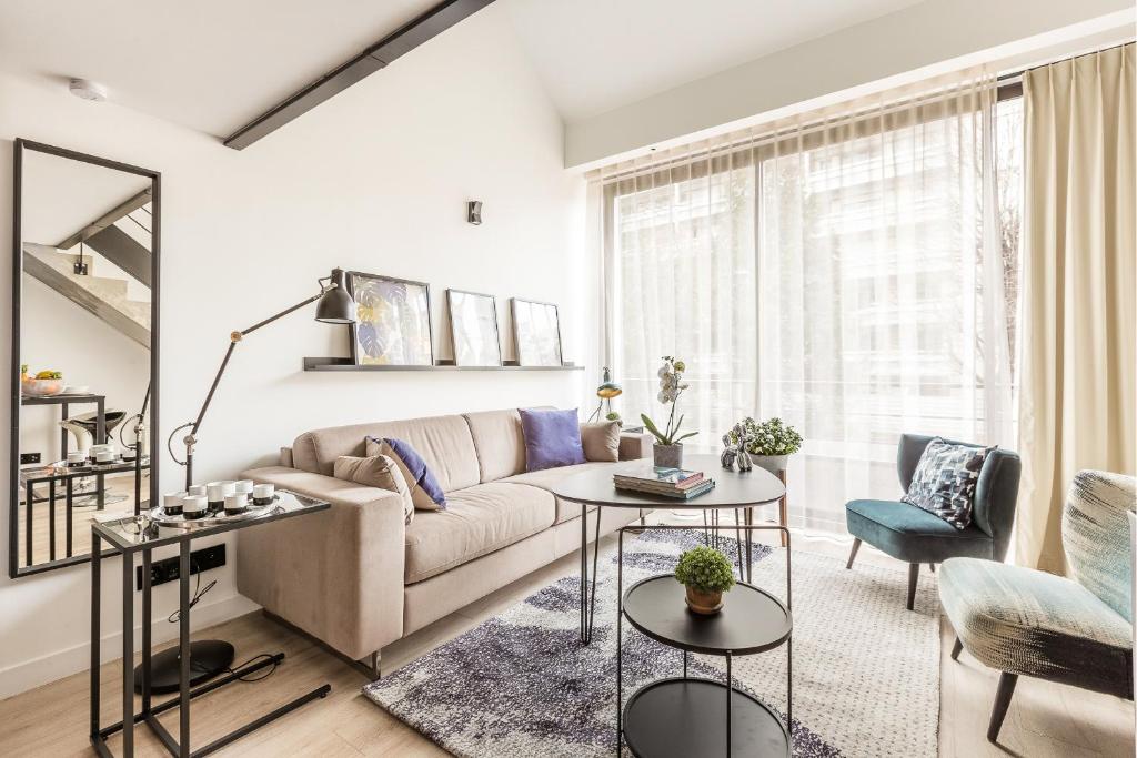 - un salon avec un canapé et des tables dans l'établissement B2 Loft Duplex 175Blo-Paris Convention, à Paris