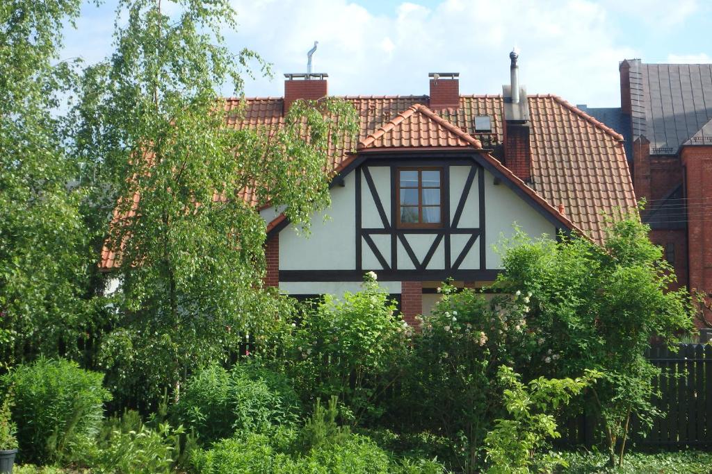 a house with a tiled roof and trees at U Aptekarzy in Szymbark