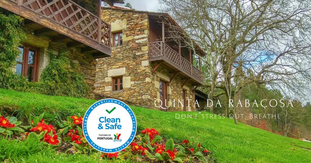 una señal frente a un edificio con flores en Quinta da Rabaçosa - Turismo Rural, en Castro Daire