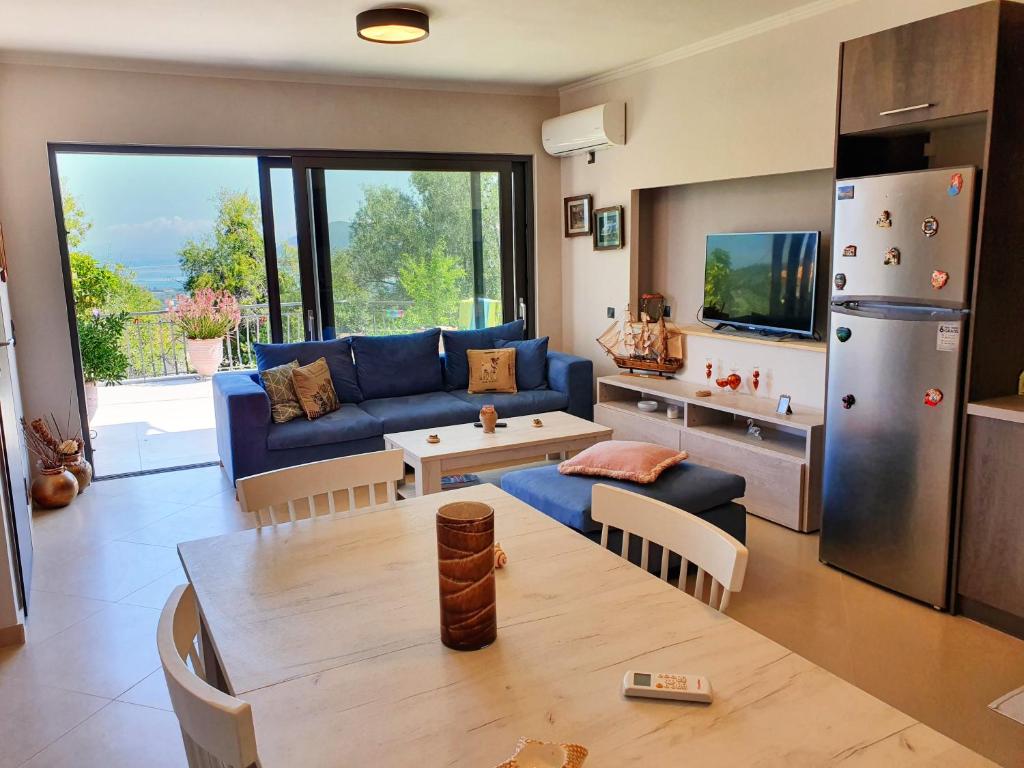 un soggiorno con divano blu e tavolo di George's Apartment a Città di Lefkada