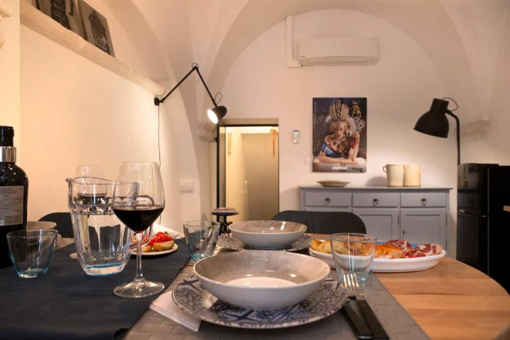 een tafel met kommen en wijnglazen erop bij La casa di Maclà in Martina Franca