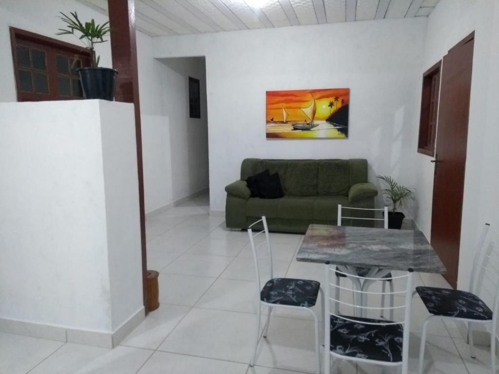 uma sala de estar com um sofá verde e uma mesa em Guest House Marinas em Angra dos Reis