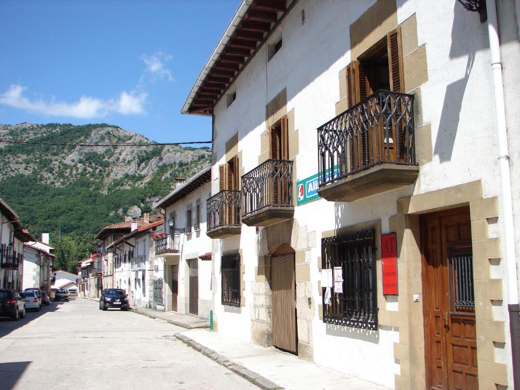 a building with balconies on a street with a mountain at Apartamentos LAZKANO I Y II in Huarte-Araquil