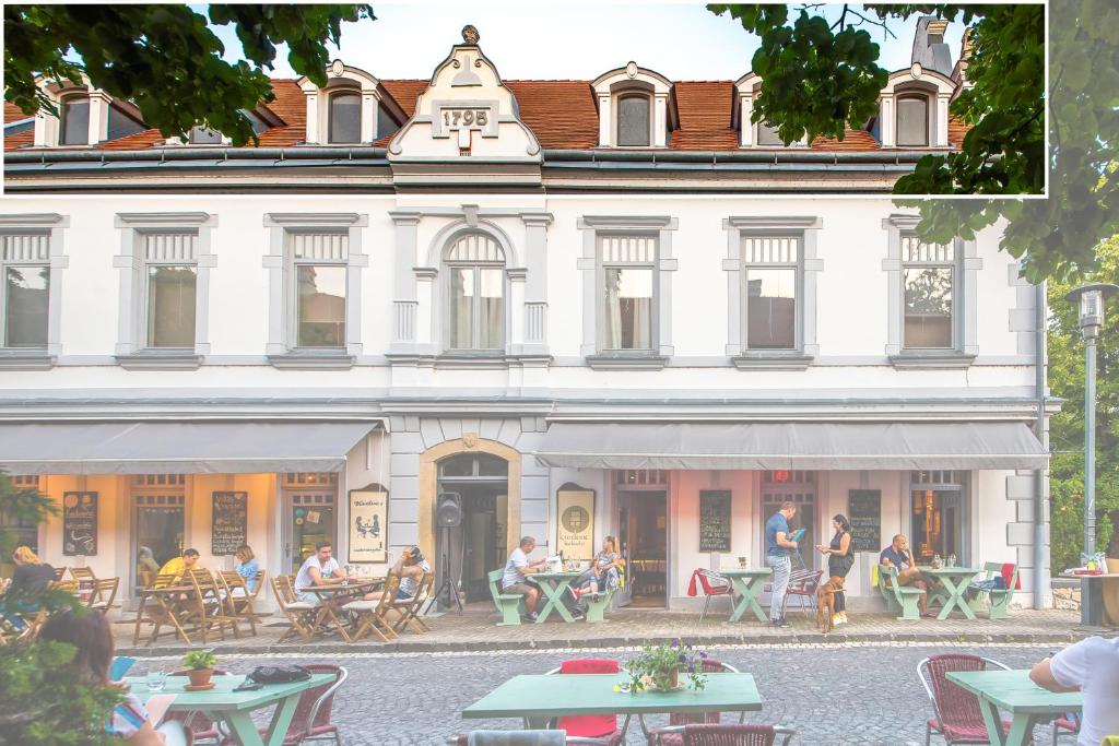a building with people sitting at tables in front of it at BLAHA ROOMS in Balatonfüred