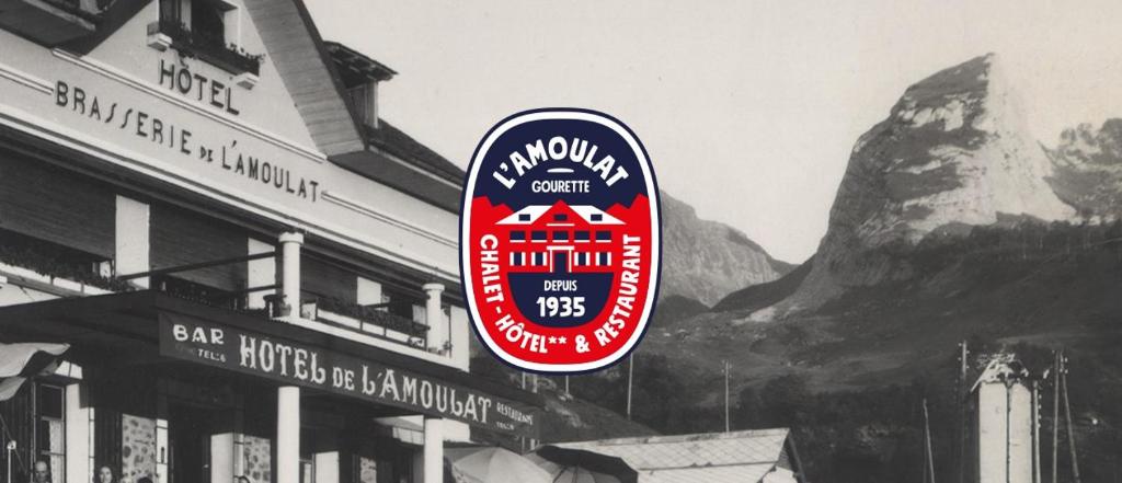 un cartel en un edificio frente a una montaña en Hôtel L'Amoulat, en Gourette