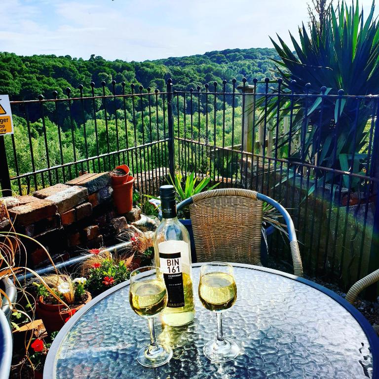 a table with two glasses of white wine on it at Gorgeview Cottage in Ironbridge