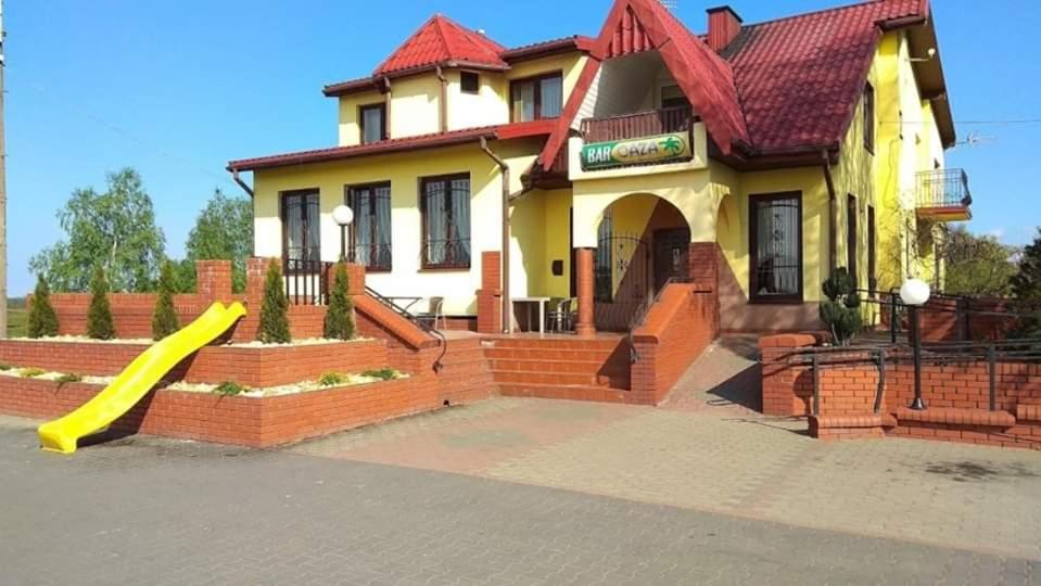 une maison avec un toboggan devant elle dans l'établissement Bar Oaza, à Szczerców