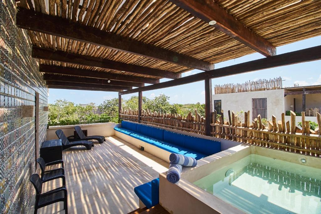 an outdoor pool with a hot tub and chairs at Casa Tribu Luum Zama in Tulum