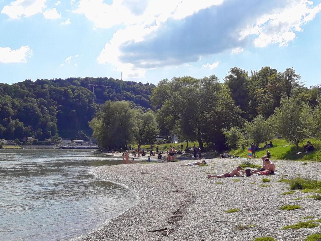 a group of people laying on a beach next to a river at Traumapartment Pöstlingberg, reservierter Parkplatz, 4 Schlafzimmer in Linz
