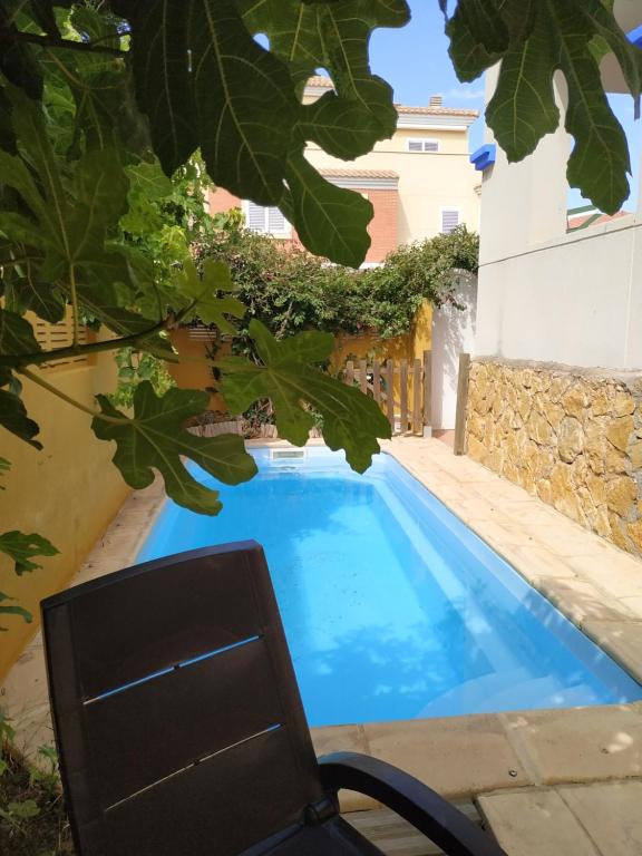 una piscina con una sedia accanto a un edificio di Oktheway Vivas Aguadulce a Roquetas de Mar