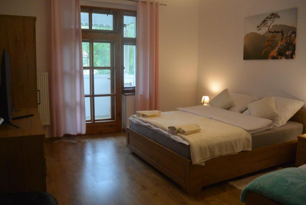 um quarto com uma cama e uma grande janela em SONIA em Polanica-Zdrój