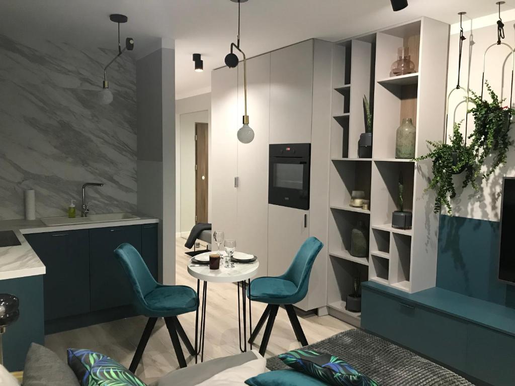 - une cuisine avec des chaises bleues et une table dans une chambre dans l'établissement SŁOŃCE WODA LAS Apartament No 11A, à Kielce