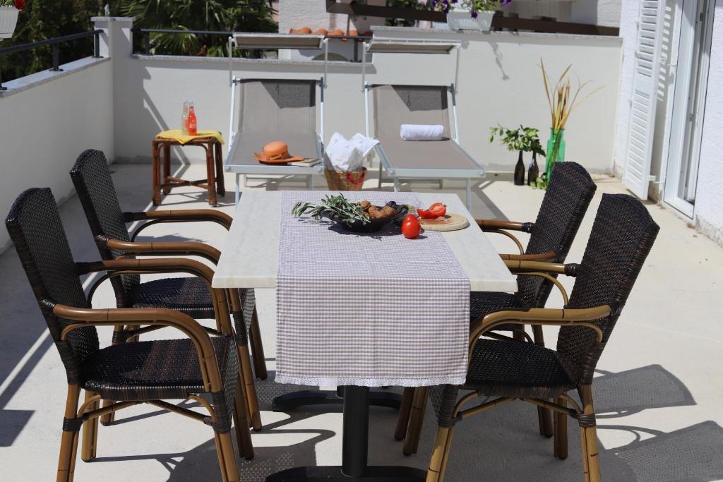 einen Tisch und Stühle auf einer Terrasse mit Essen drauf in der Unterkunft App Sanny with nice terrace in Malinska