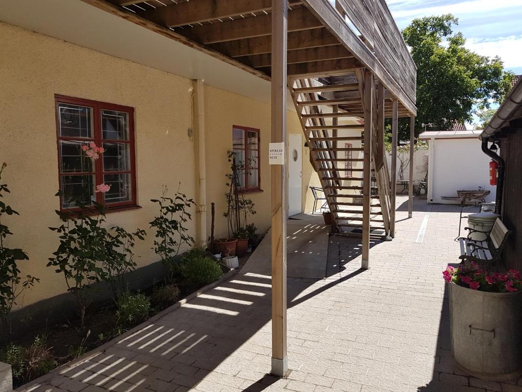 une terrasse avec un escalier en colimaçon en bois à côté d'un bâtiment dans l'établissement Adelsgatan 36 lägenhetshotell, Gotland Living and Meeting, à Visby