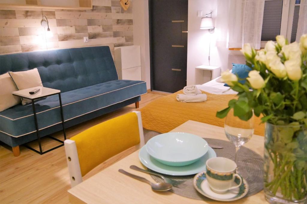 a living room with a blue couch and a table at Apartamenty i Mieszkania Wakacyjne in Chałupy