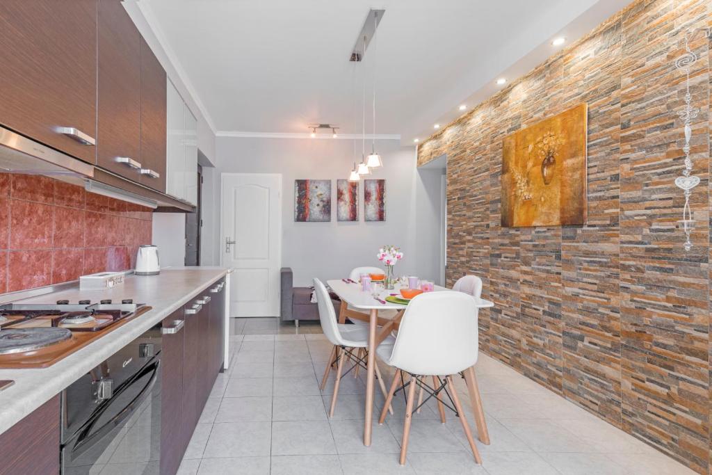 kuchnia ze stołem i ceglaną ścianą w obiekcie 3- Sea view luxury suite in the center of Rhodes! w mieście Rodos