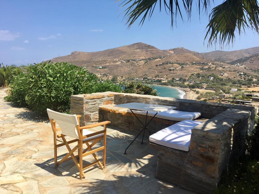 a table and chairs on a stone patio with a view of the ocean at Sophie's choice in Otzias