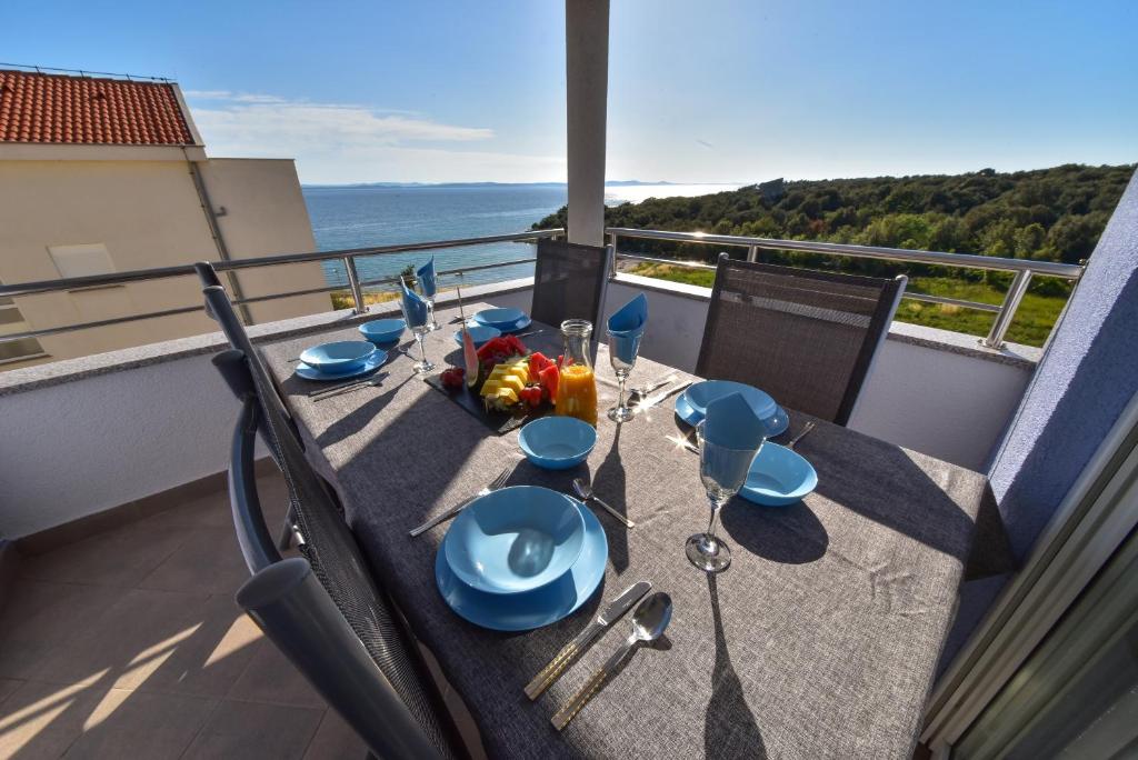 - une table sur un balcon avec vue sur l'océan dans l'établissement Apartmani Rudius, à Kožino