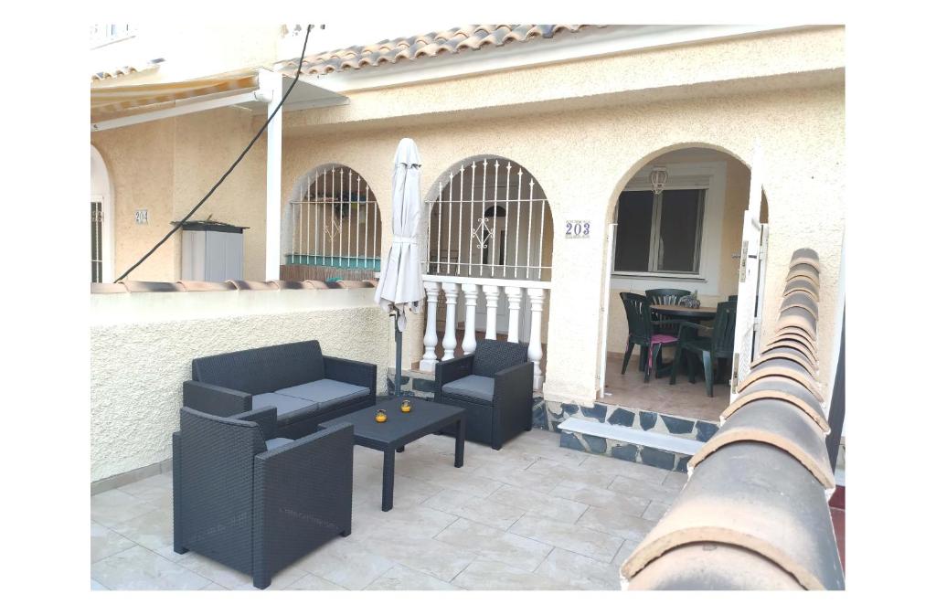 a patio with two chairs and a table at BUNGALOW ACOGEDOR EN GRAN ALACANT in Gran Alacant