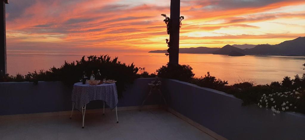 stół i krzesła na balkonie z widokiem na zachód słońca w obiekcie Blue Mediterranean Apartments w miejscowości Sveti Stefan