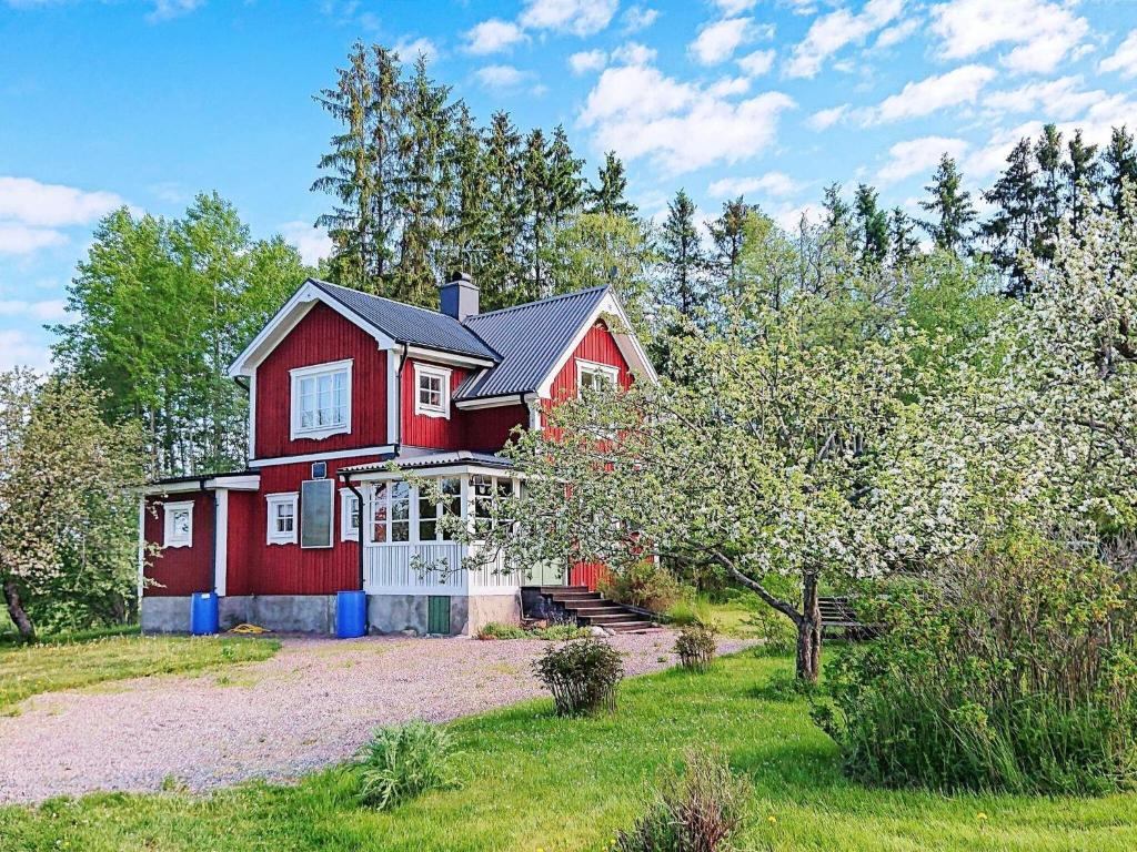 Uma casa vermelha com um portão branco à frente. em 5 person holiday home in STORVIK em Storvik