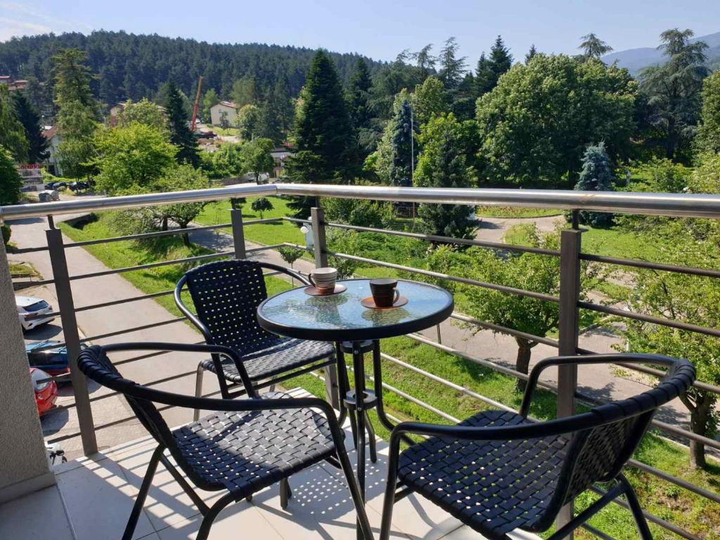 una mesa y sillas en un balcón con vistas en Happy, en Vrnjačka Banja