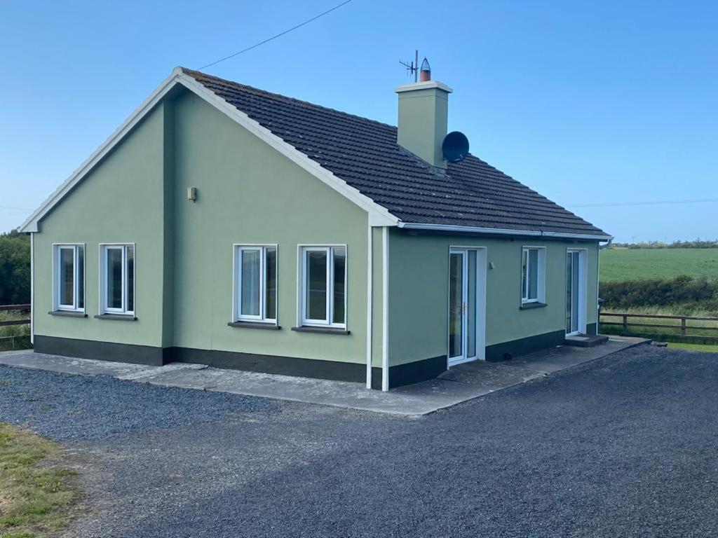 a green and white house with a driveway at Gurraun House in Kilkee