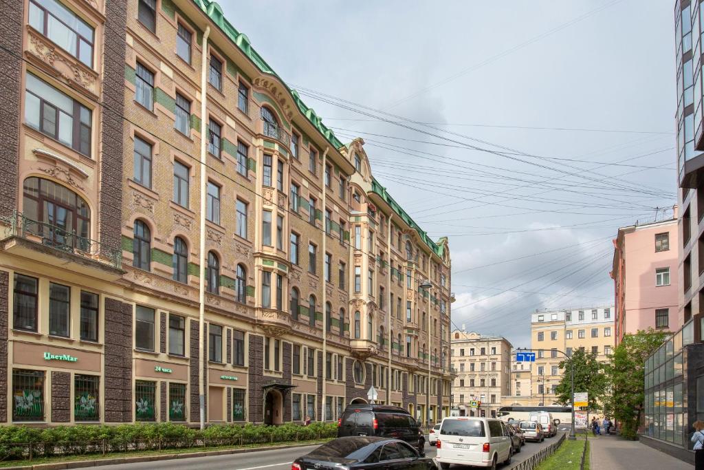 una calle de la ciudad con coches estacionados frente a los edificios en Mom, I'm Home, en San Petersburgo