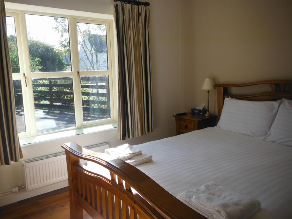 a bedroom with a bed and a large window at Inspiration Lodge in Anascaul