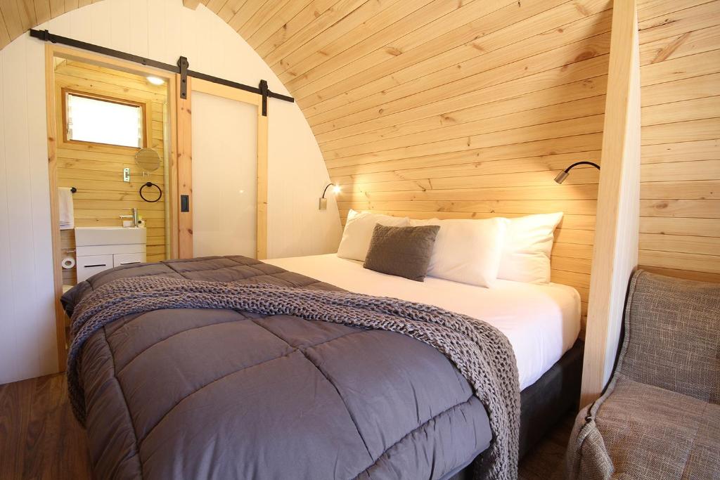 a bedroom with a large bed in a wooden room at Wonthaggi Park Lane Holiday Park in Wonthaggi