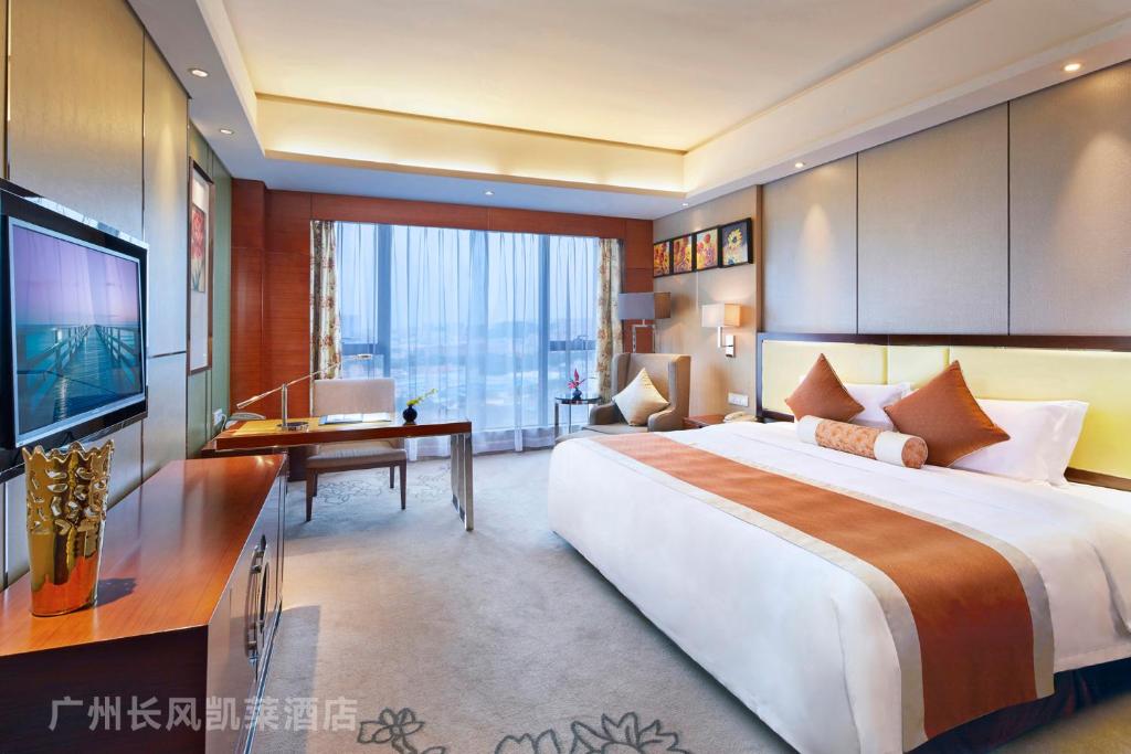 Habitación grande con cama grande y escritorio. en Guangzhou ChangFeng Gloria Plaza Hotel, en Zengcheng