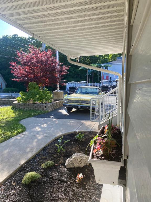 a porch with a garden with a car on a street at Bay Lodging Resort in Put-in-Bay