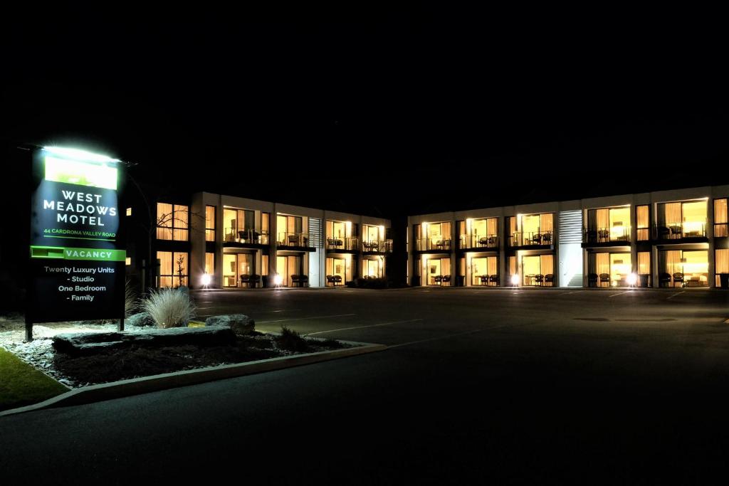 a building with a sign in front of it at night at West Meadows of Wanaka in Wanaka