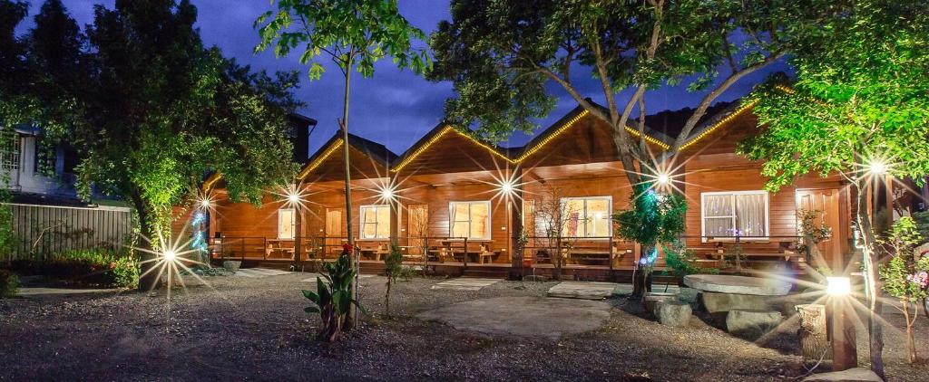 a wooden house with lights in front of it at YingChia SPA Homestay in Luye